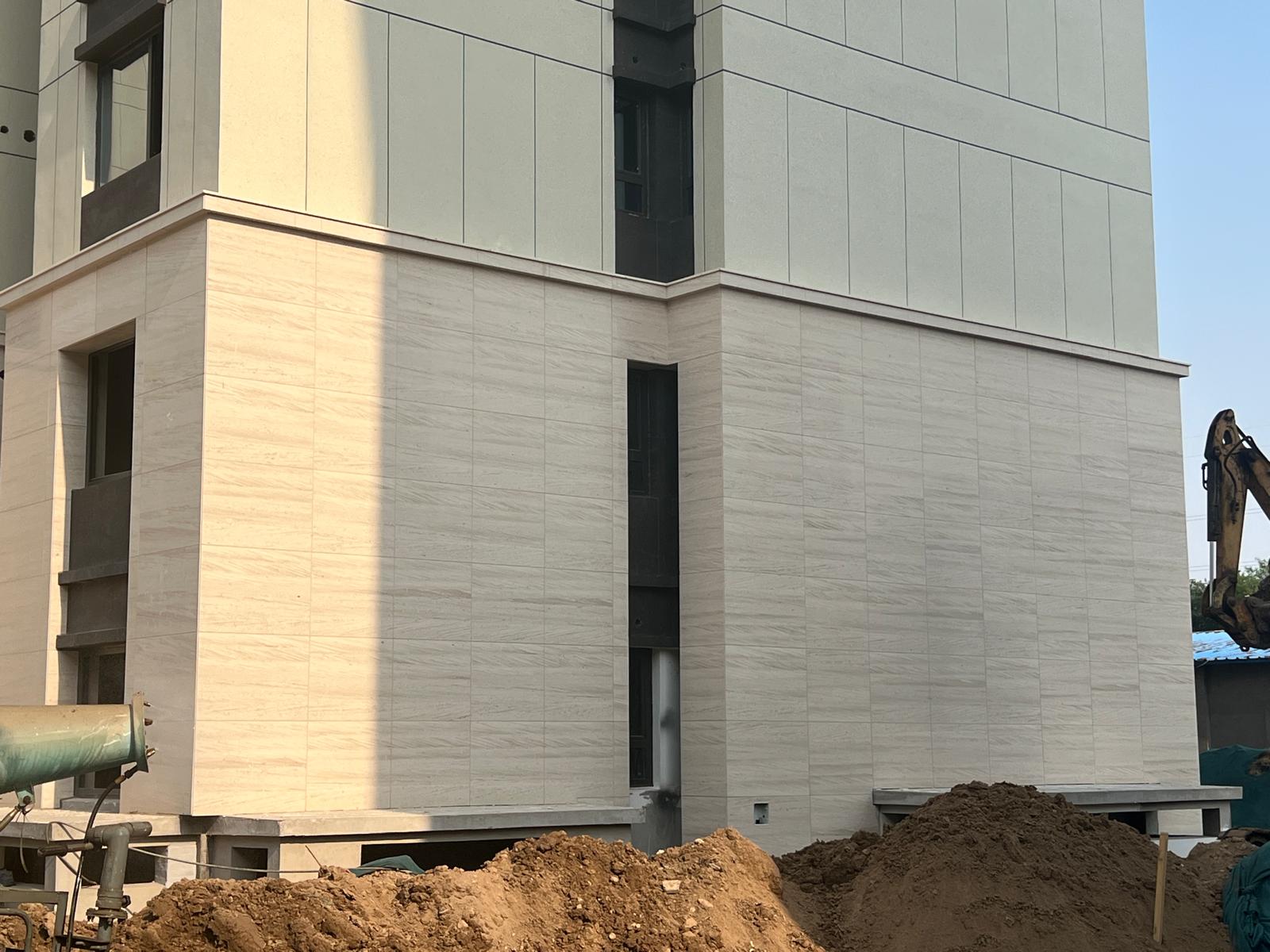 Fachada contemporânea revestida em pedra Moca Creme